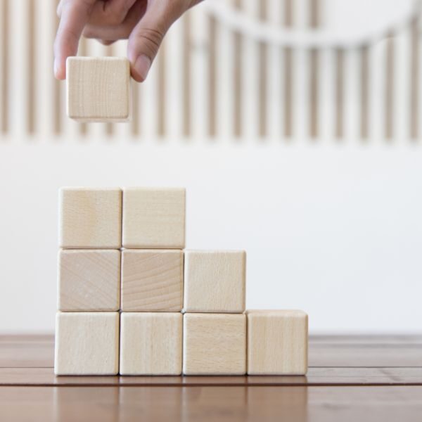 Blocs en bois empilés symbolisant les avantages et les limites du portage salarial pour un indépendant