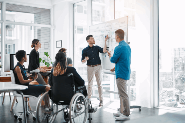 Professionnels collaborant lors d’une réunion de travail inclusive illustrant le portage salarial pour les personnes en situation de handicap