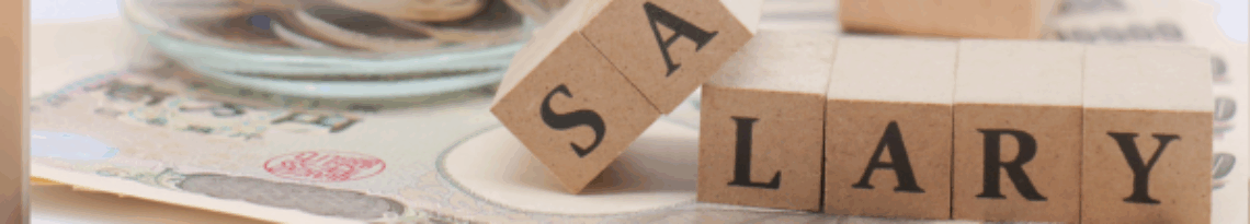 Illustration du salaire en portage salarial avec lettres en bois, billets et pièces symbolisant la rémunération de l’indépendant